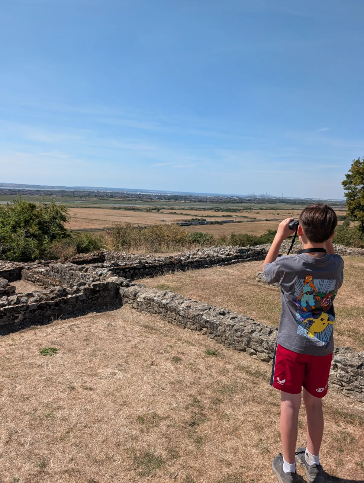 Child looking through binoculars from Hadleigh Castle across the Essex countryside.
